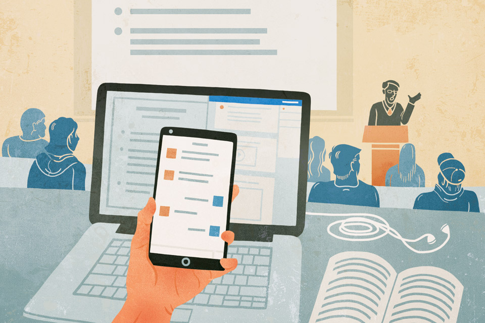 Student looking at their smartphone while on a latop in a lecture